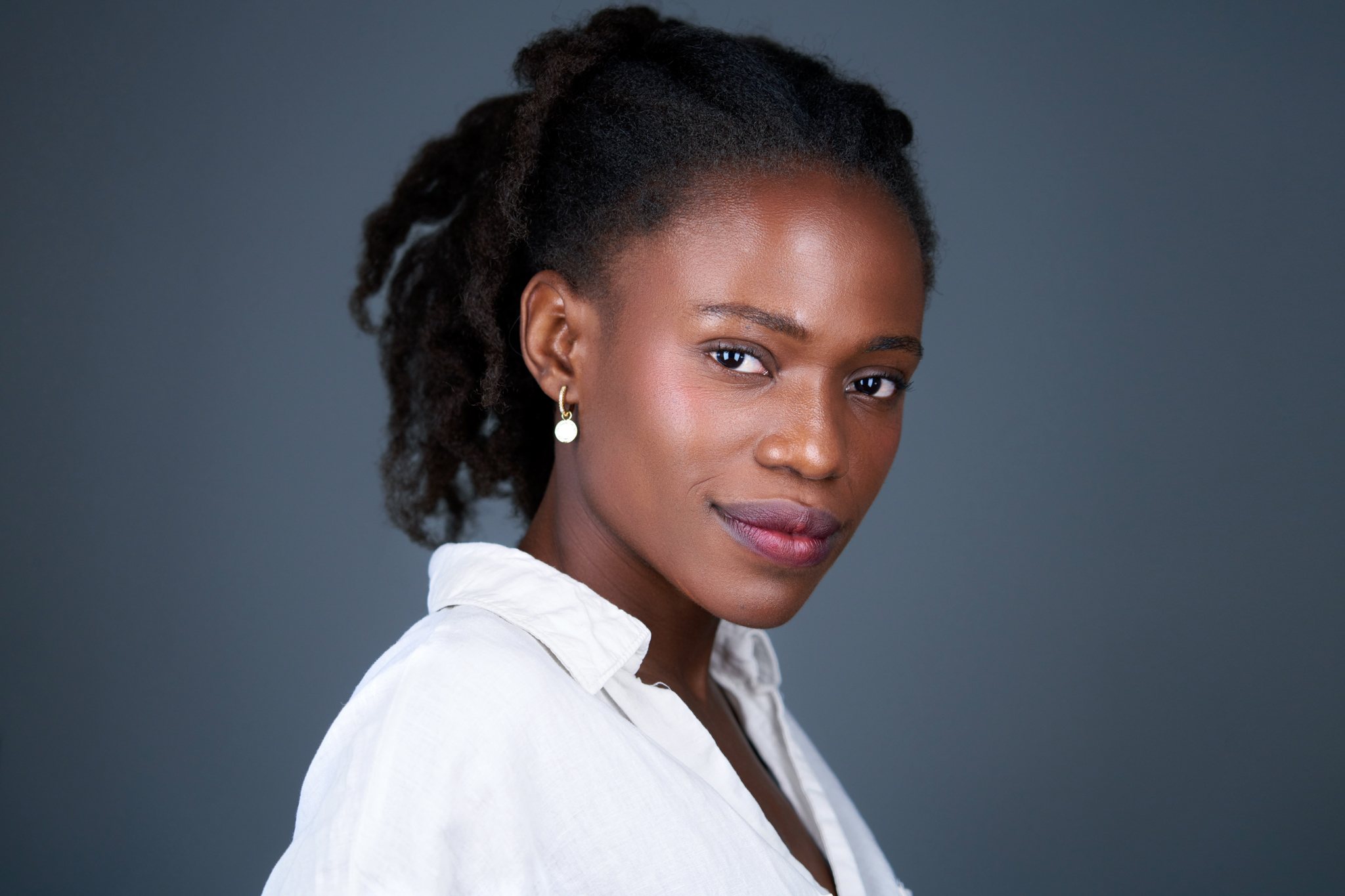 Studio headshot of a man with long locs