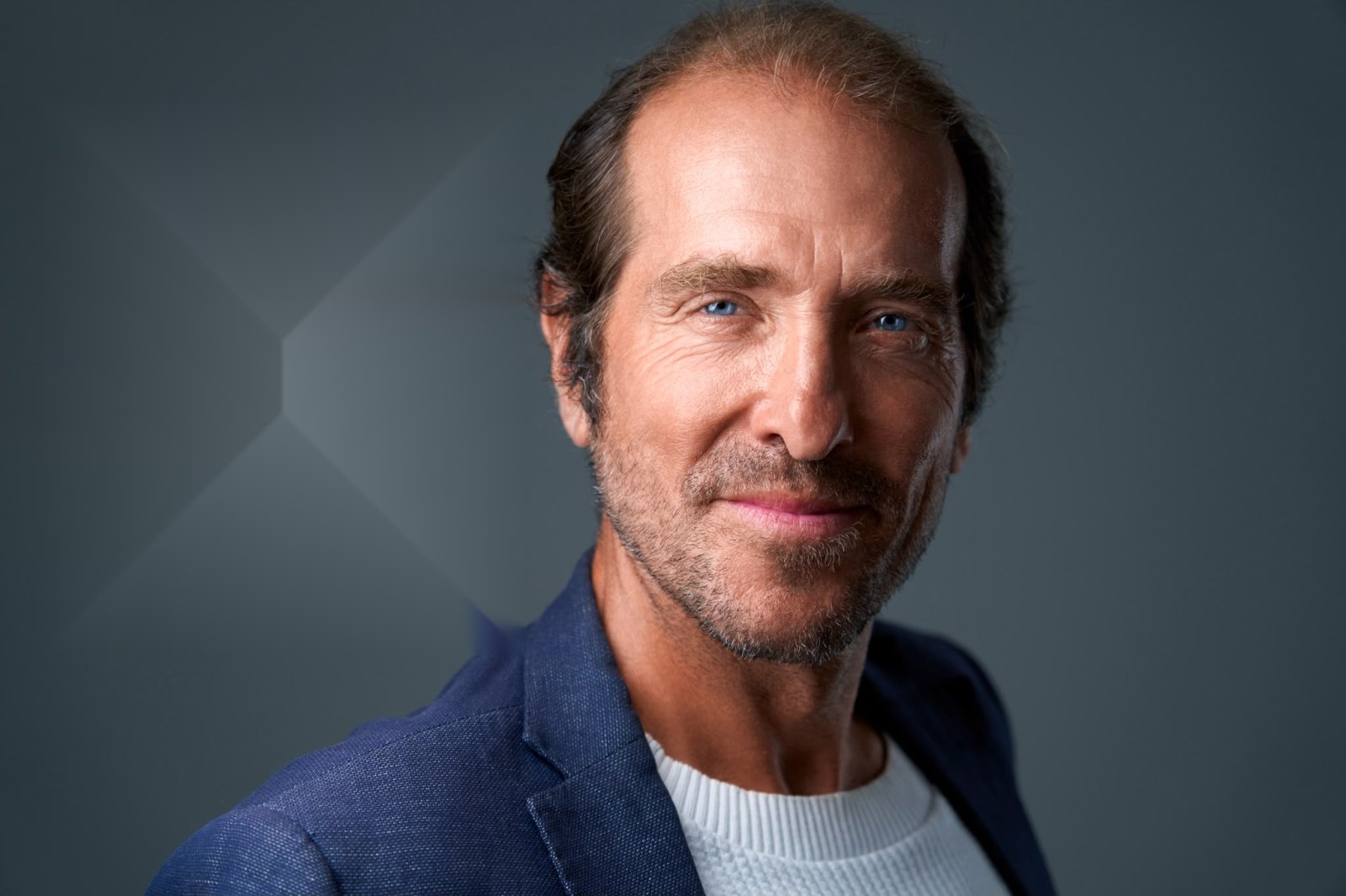 Headshot of a man in a navy blazer