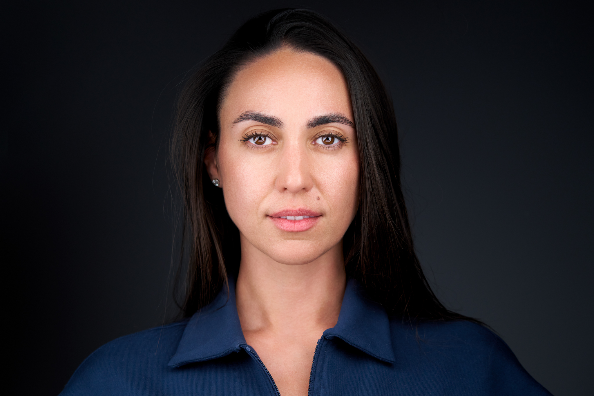 Studio headshot of a woman with straight dark hair